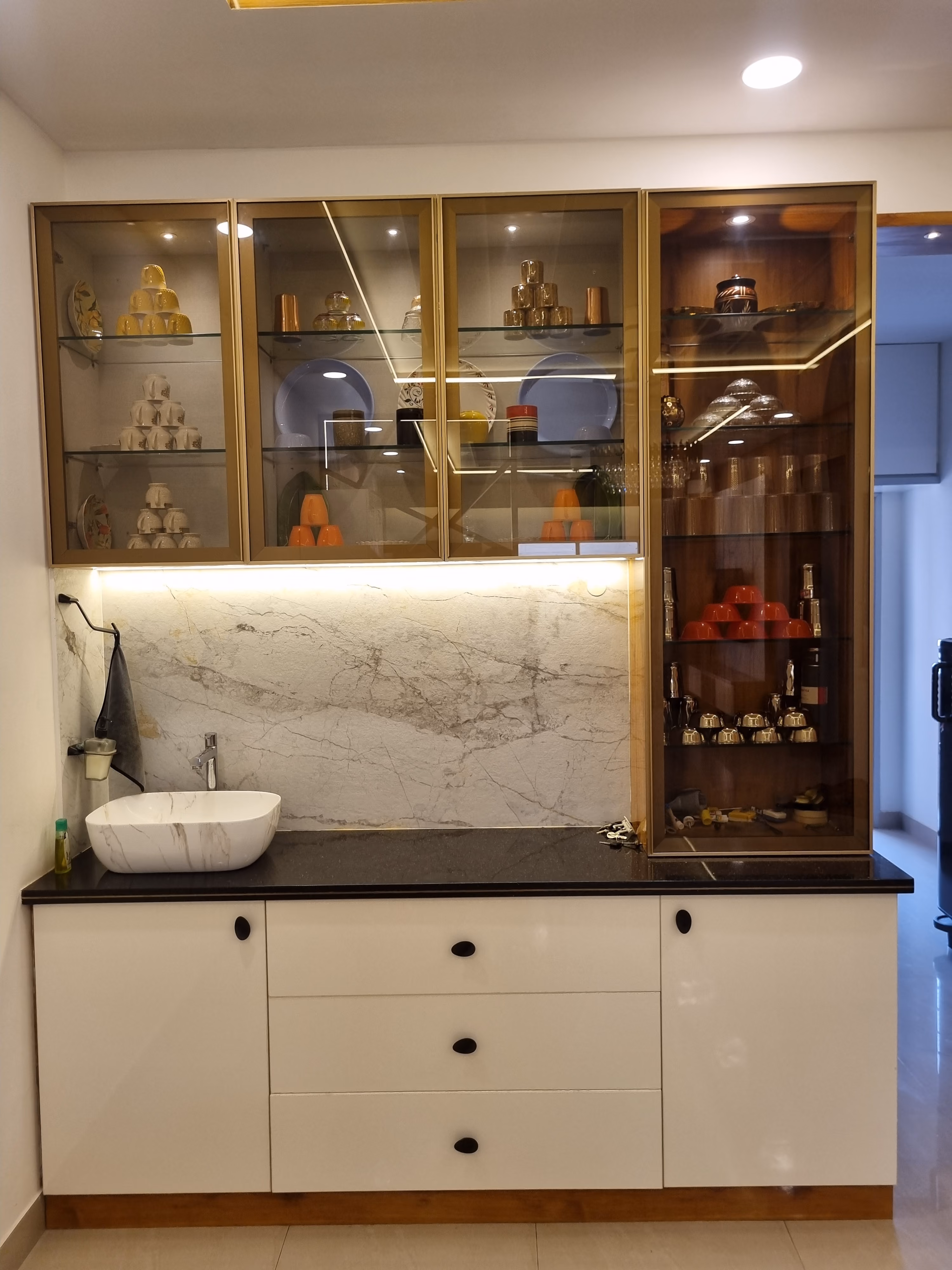 Crockery and dining unit with gold-trimmed glass shelving